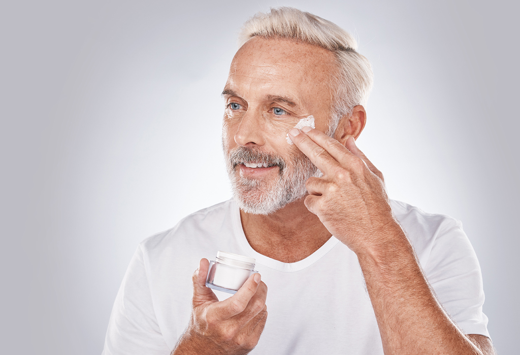 good looking older man applies eye cream