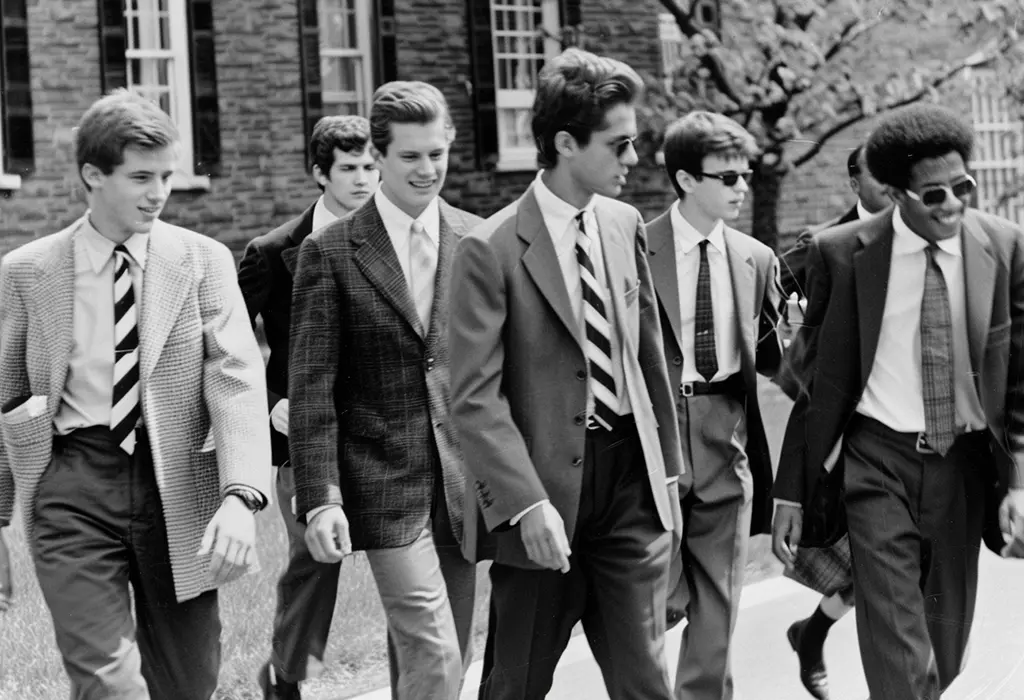 group of smartly-dressed ivy league students on a college campus in the early 1960s