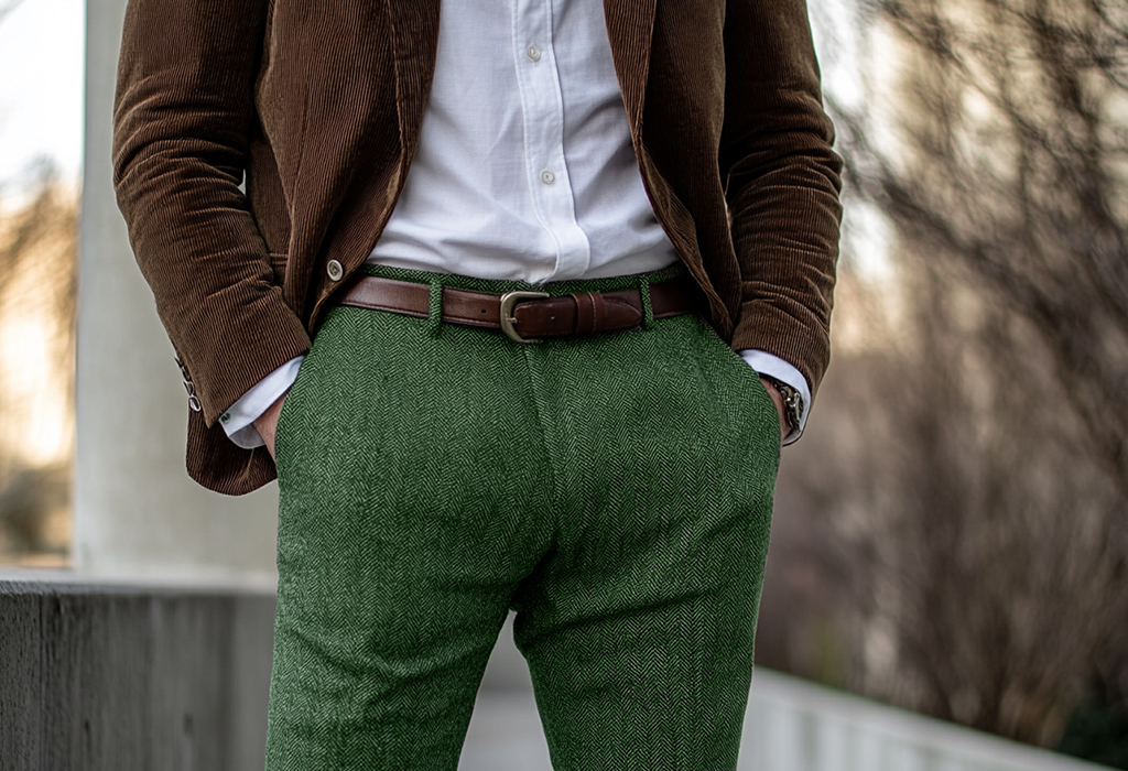 man wearing green herringbone wool pants with a white oxford shirt and a brown corduroy blazer