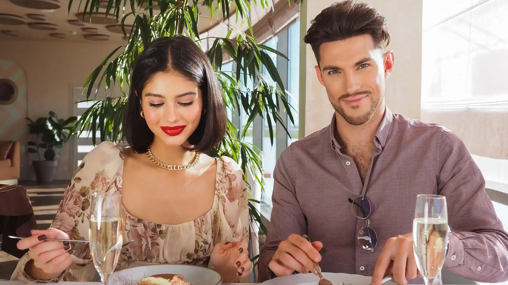 Couple sitting side by side having lunch together during a date.