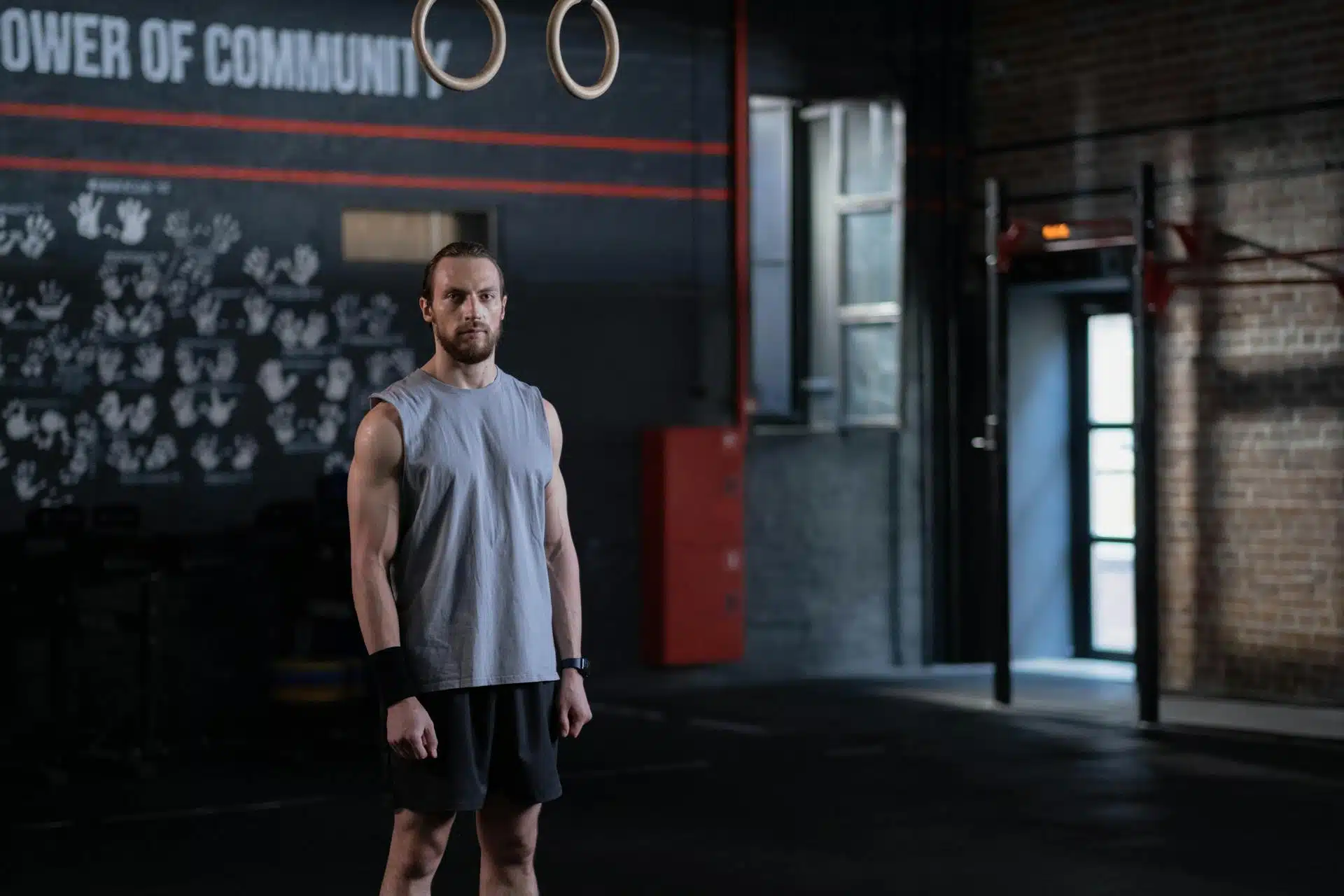 A muscular man standing in the middle of a gym.