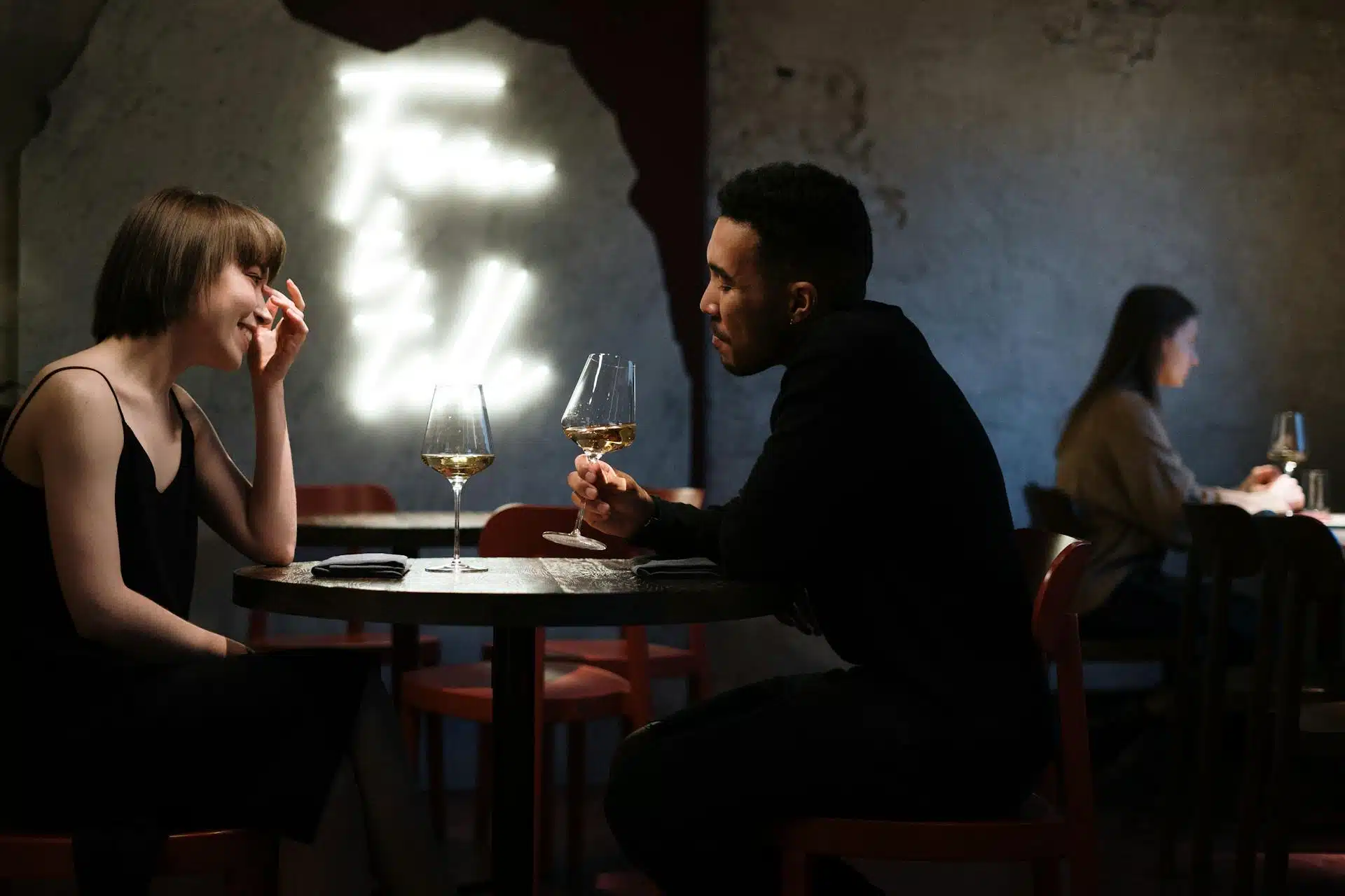 A couple in black having drinks.