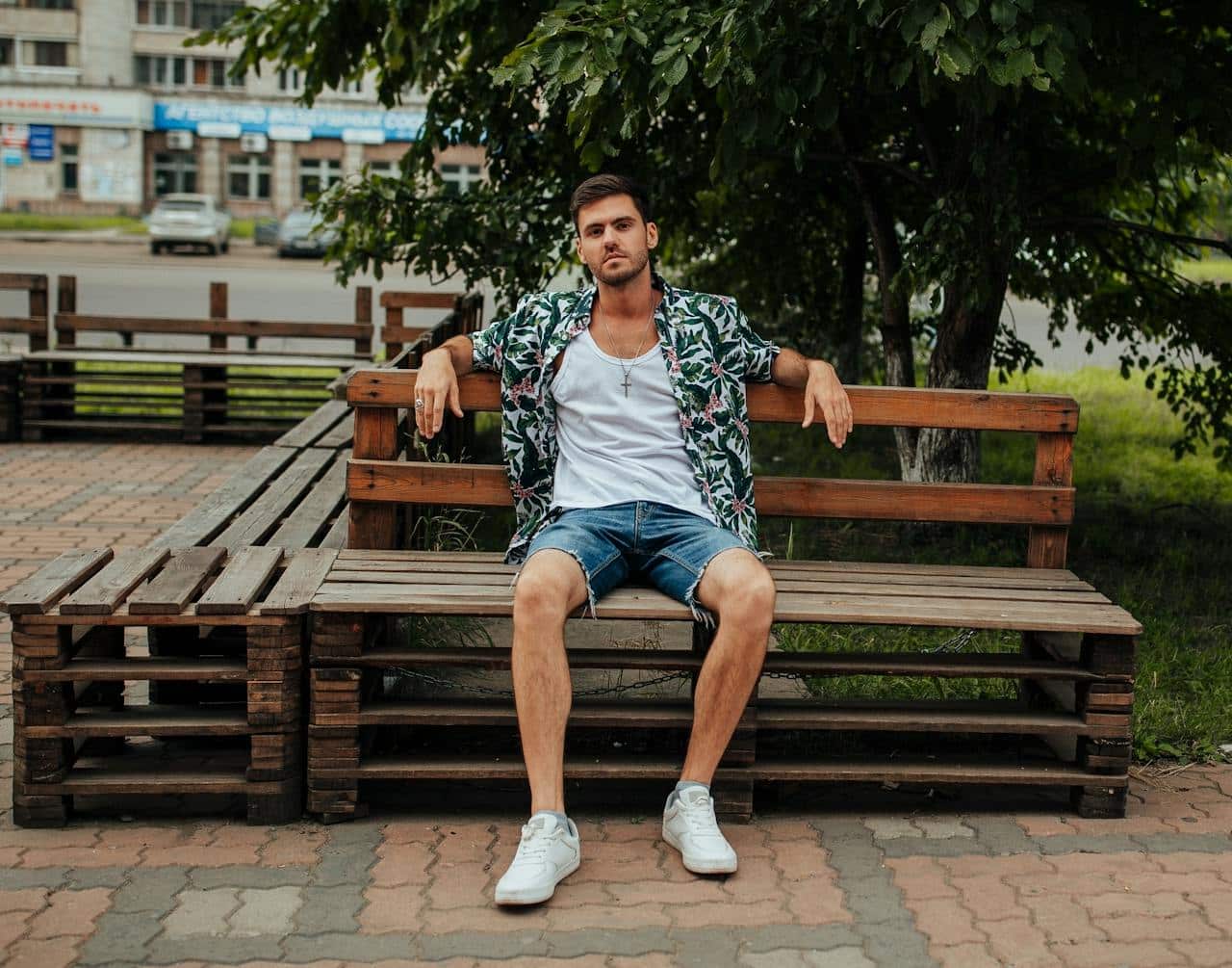 A Stylish Man Sitting on a Wooden Bench.