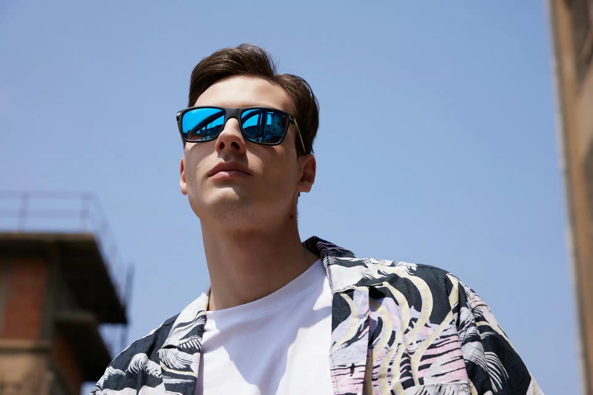 Man wearing a reflective blue sunglasses.