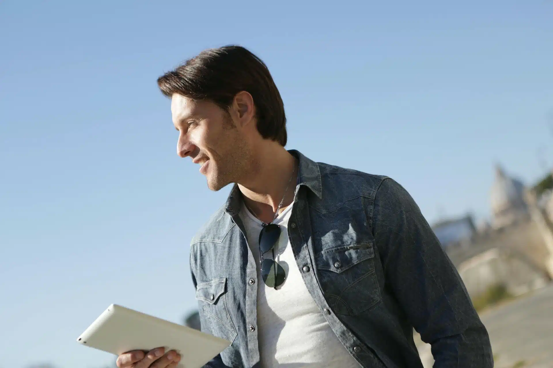 Man in Denim Jacket Holding White Tablet