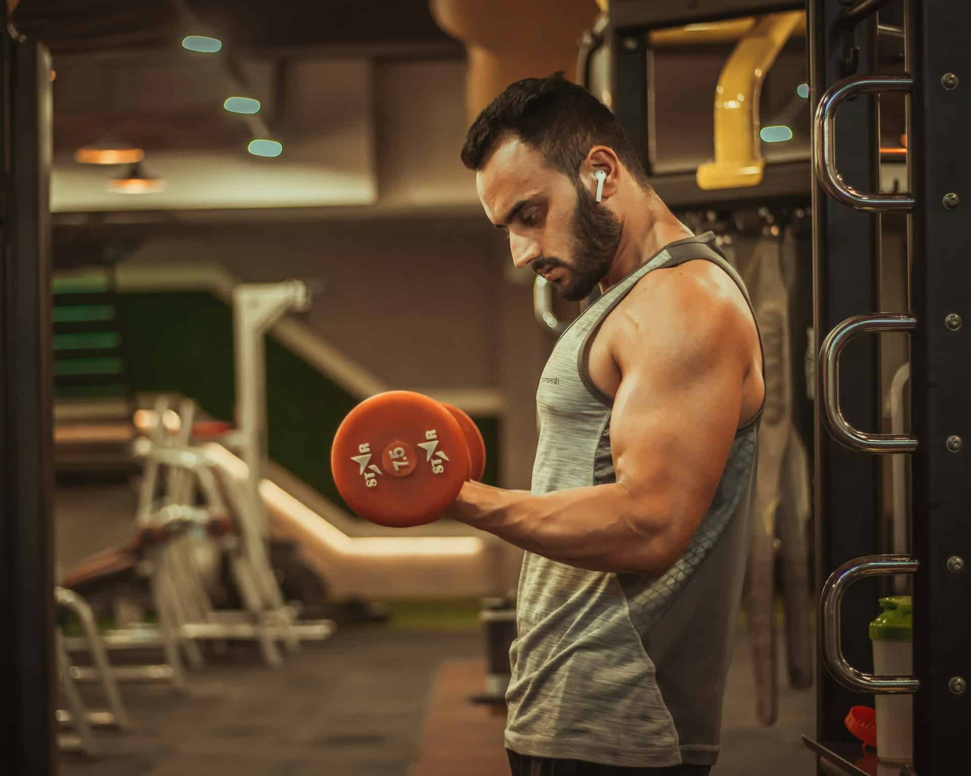 Man doing bicep curls in a gym.