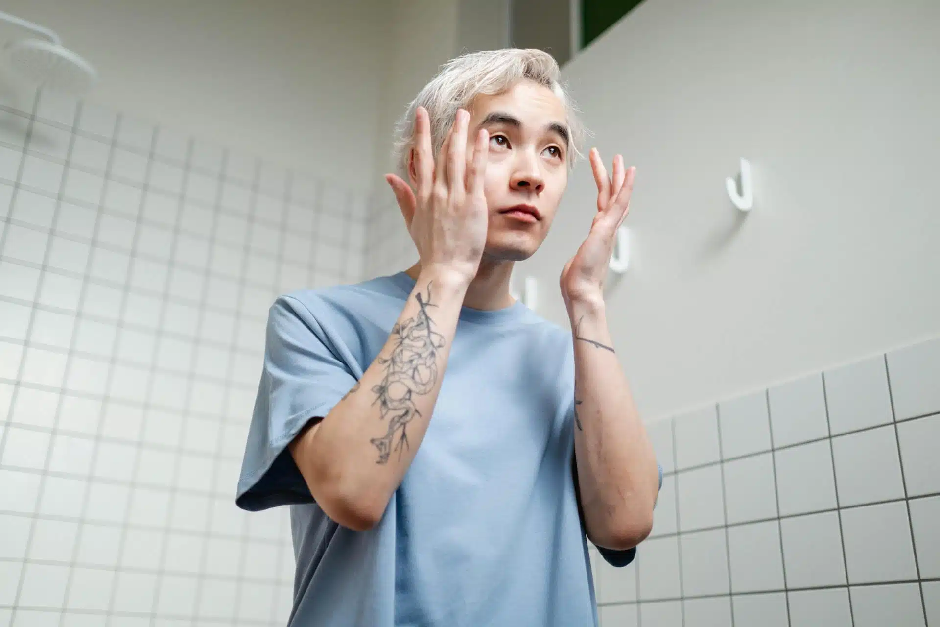 Man in Blue Crew Neck T-shirt Fixing His Eyebrows.