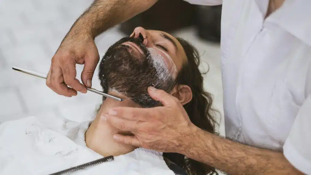 Barber Adjusting a Man's Neckline.