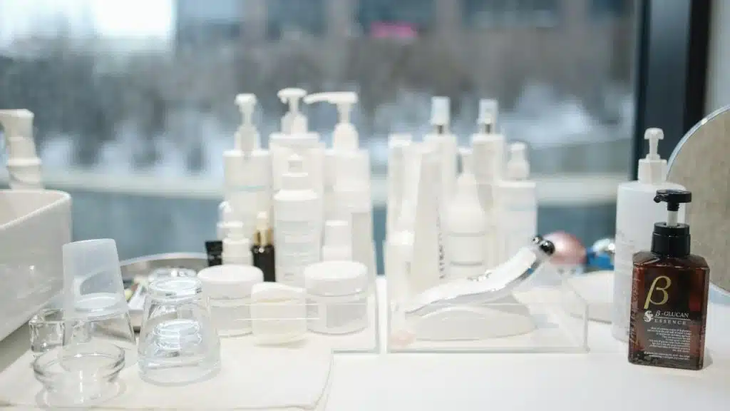 An assortment of beauty products lined up by the window at a salon.