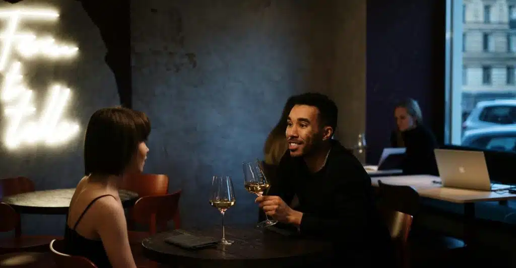 Couple on a date, engaged in conversation while enjoying drinks.