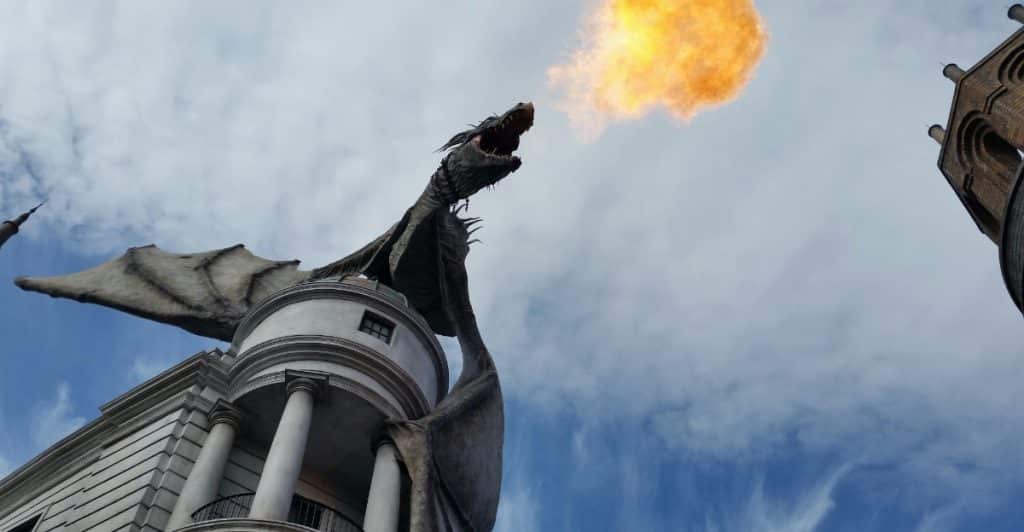 Sculpture of a fire breathing dragon on top of a building.