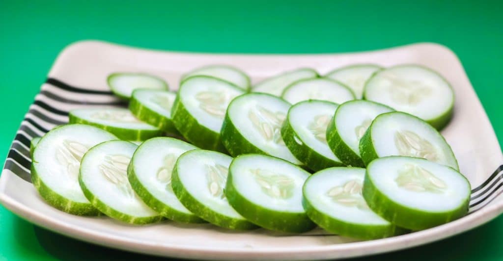 Slices of Cucumber on a White Plate with Black Stripes