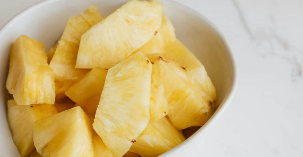 Sliced Pineapple in a White Bowl.
