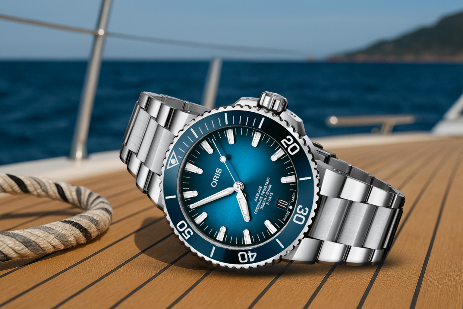 Oris Aquis Date dive watch with a sunburst blue dial and stainless steel bracelet, resting on a yacht deck beside a coiled rope with the open sea in the background