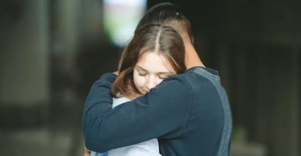 A man and a woman hugging passionately with closed eyes.