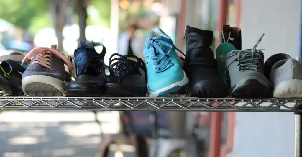 Several pairs of shoes displayed on a metal rack.