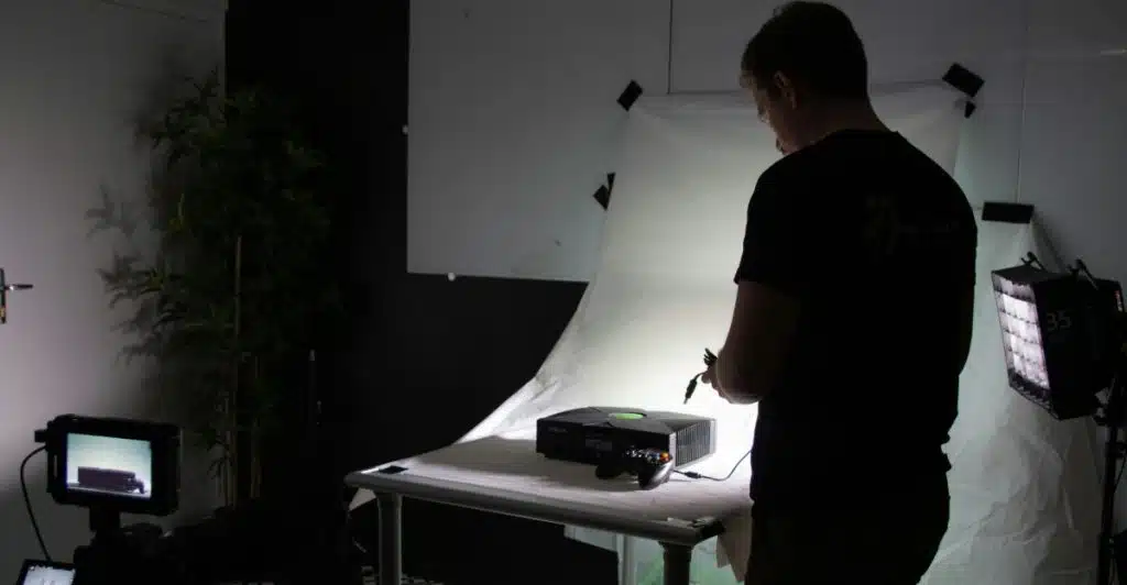 A person setting up electronic equipment in a studio-like environment.