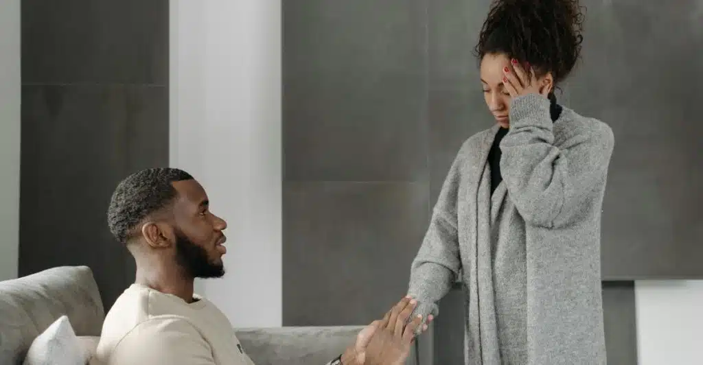 A man comforting a distressed woman on a couch.