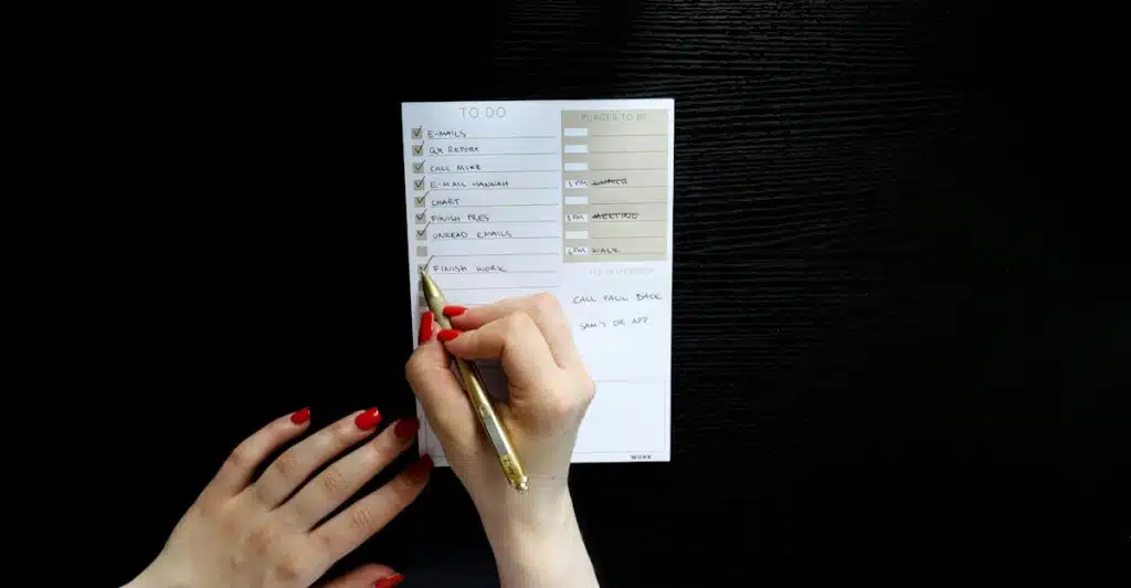 Hand writing on a to-do list with check boxes.