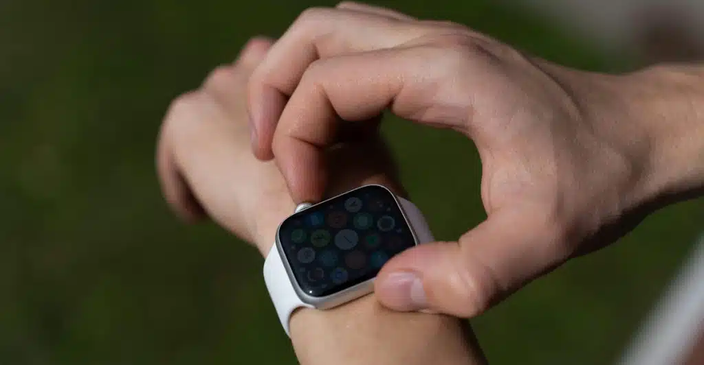A person is looking at a smartwatch on their wrist outdoors.
