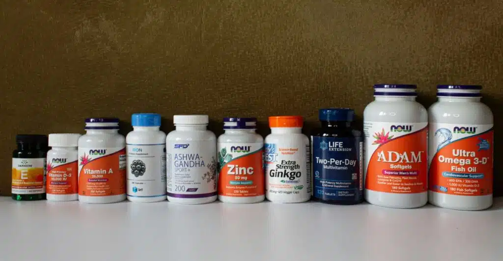 An assortment of supplement bottles lined up against a textured brown backdrop.