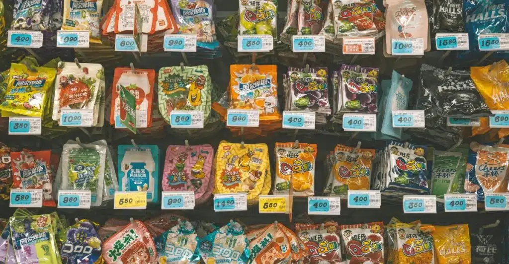 A store shelf filled with colorful packages of various processed snack foods.
