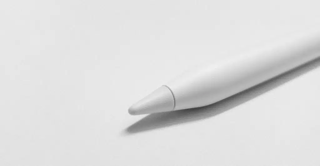 The tip of a white smart pen resting on a plain white surface.