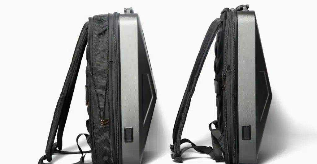 Two dark gray smart backpacks with hard shells standing upright against a white background.