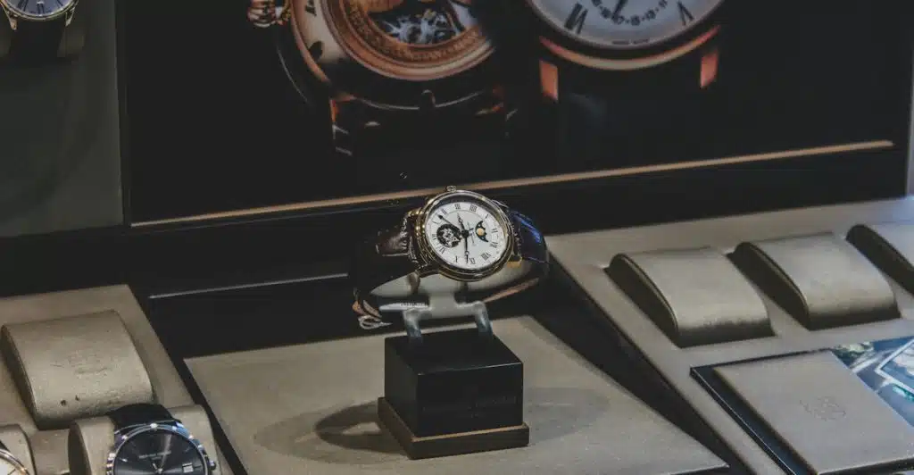 A display of multiple wristwatches, with one prominent watch on a stand in the foreground.
