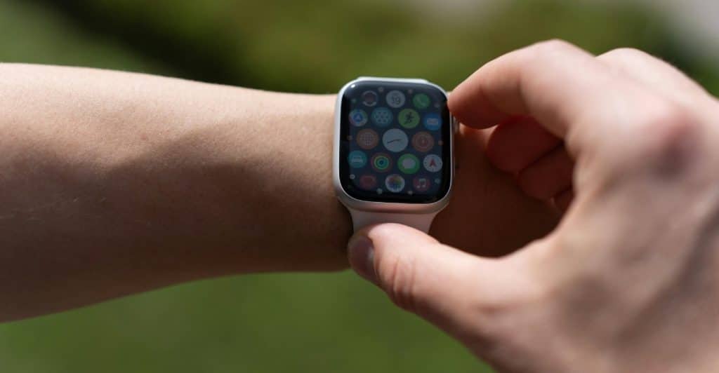 A hand interacting with an Apple Watch Series 10 on a wrist.