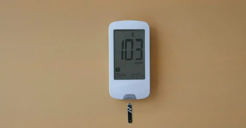 A white digital smart thermometer with a reading of "103" and a connected probe.