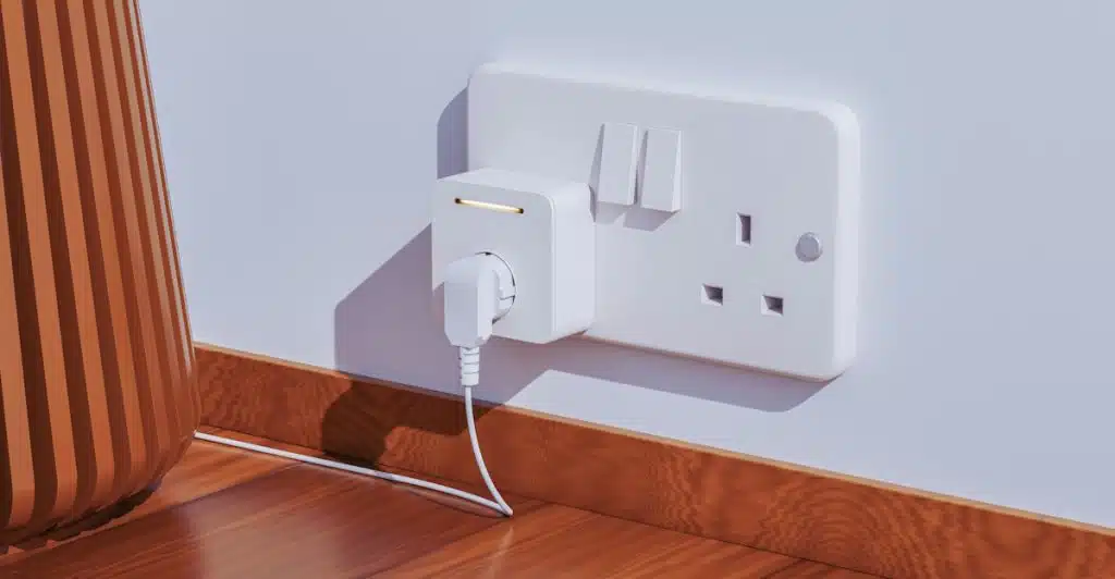 A white smart plug inserted into a wall outlet with a cord plugged into it.