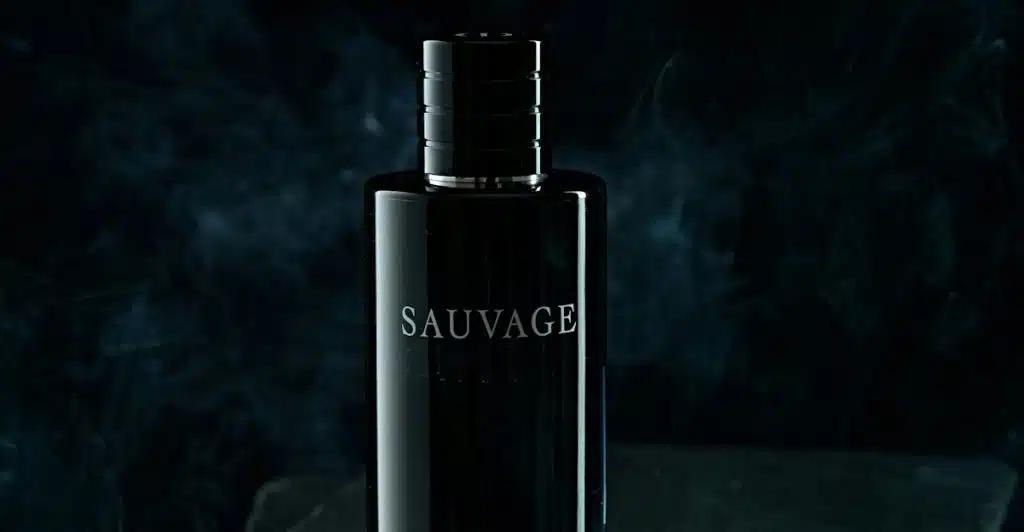 A Dior Sauvage Elixir fragrance bottle on a dark surface with smoke in the background.