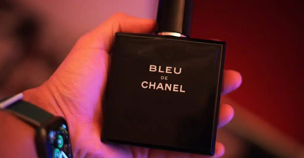 A hand holding a Chanel Bleu de Chanel (Parfum) fragrance bottle.