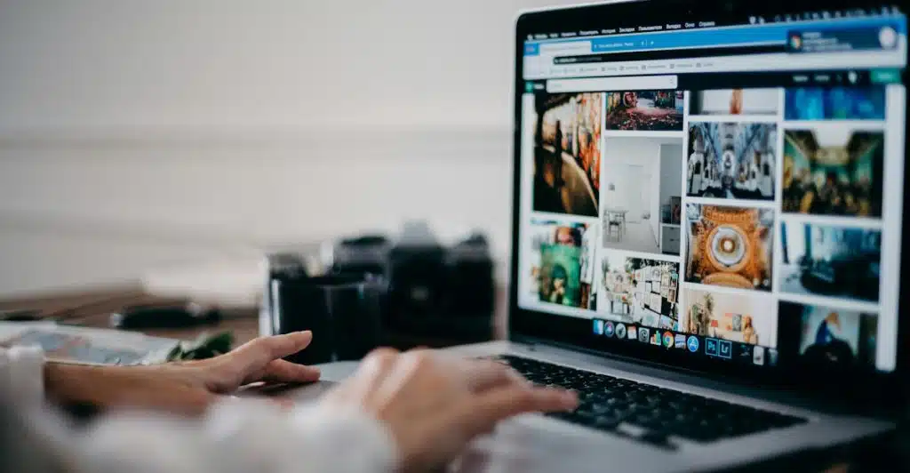 A person's hands typing on a laptop keyboard, with various images displayed on the screen.