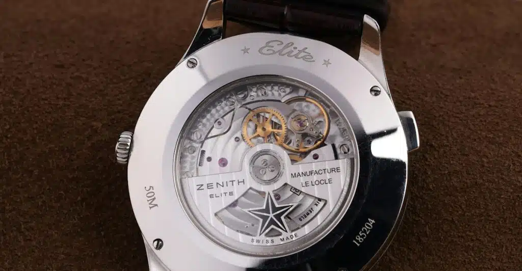 The exposed intricate mechanical movement of a luxury watch, showcasing gears and other components.