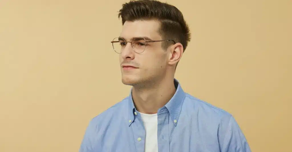 A man with a side part haircut and glasses looking to the right.