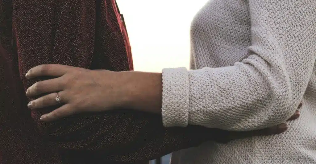A close-up view of a couple holding arms.