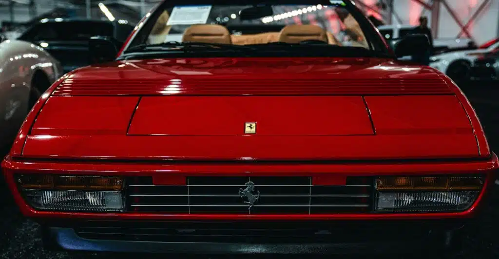 The front view of a red 1984 Ferrari Testarossa, showing its grille and pop-up headlights.