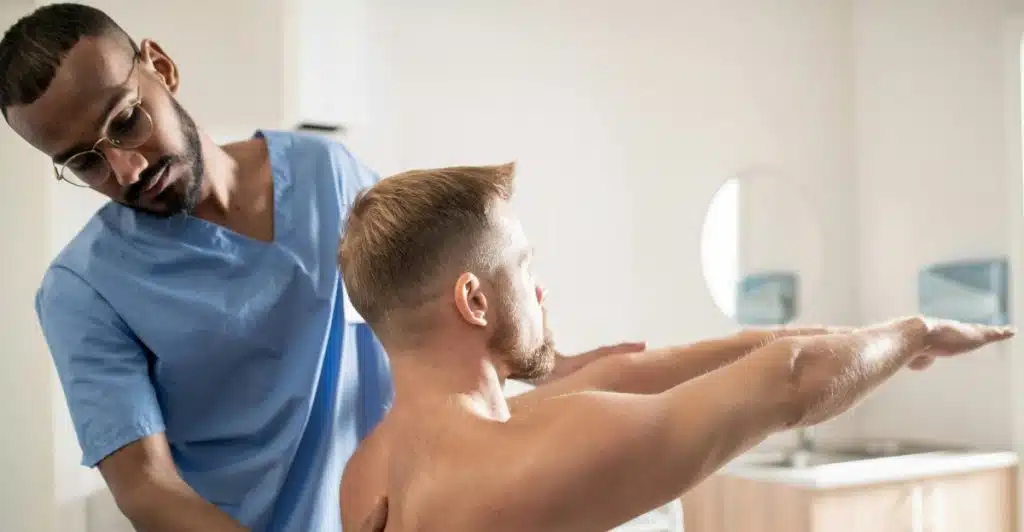 A physical therapist assisting a man with an arm stretch during an exercise.