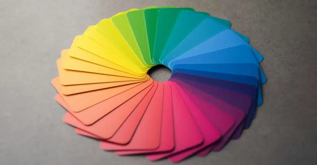 A circular arrangement of color swatches showing a full spectrum of hues, fanned out on a grey surface.