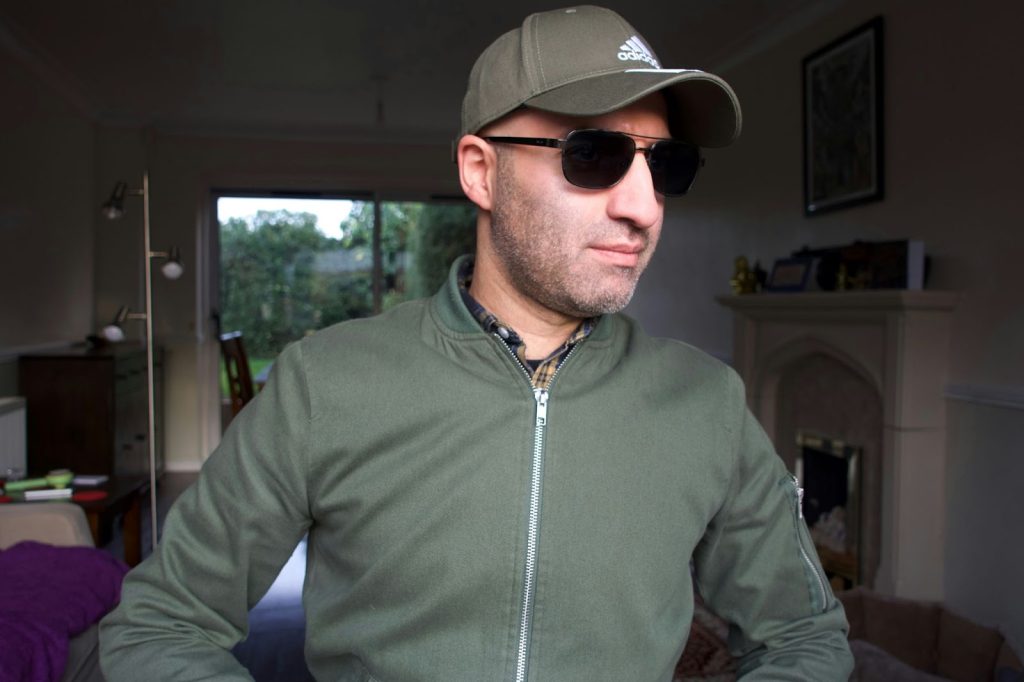 A man wearing an army green jacket.