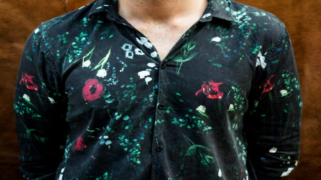 A man wearing black button-up shirt with flowers