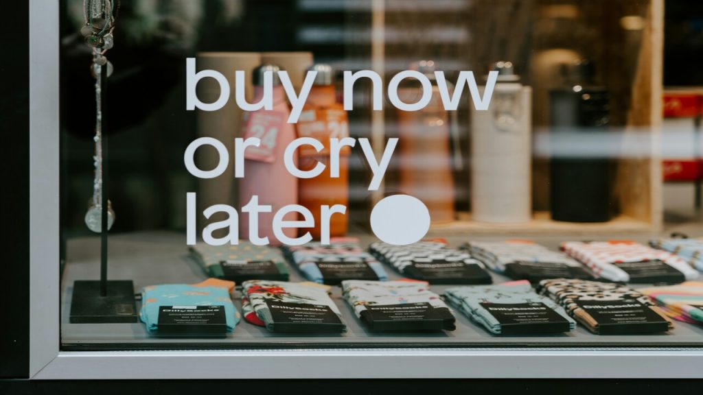 A sign at a store saying “buy now or cry later”