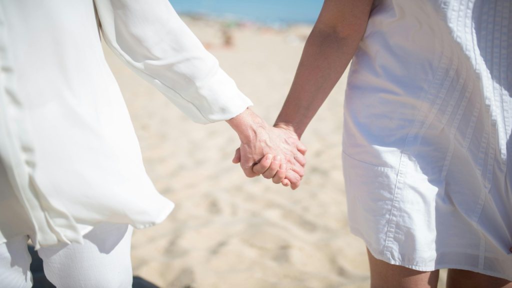 Couple holding each other’s hands while walking.
