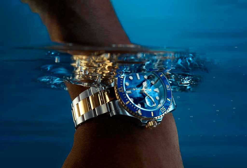 Rolex Submariner two-tone dive watch partially submerged in water, showcasing its luxury design and waterproof capabilities