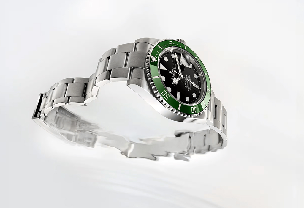 Rolex Submariner with green bezel and black dial displayed on a reflective surface, highlighting its stainless steel bracelet and iconic dive watch design