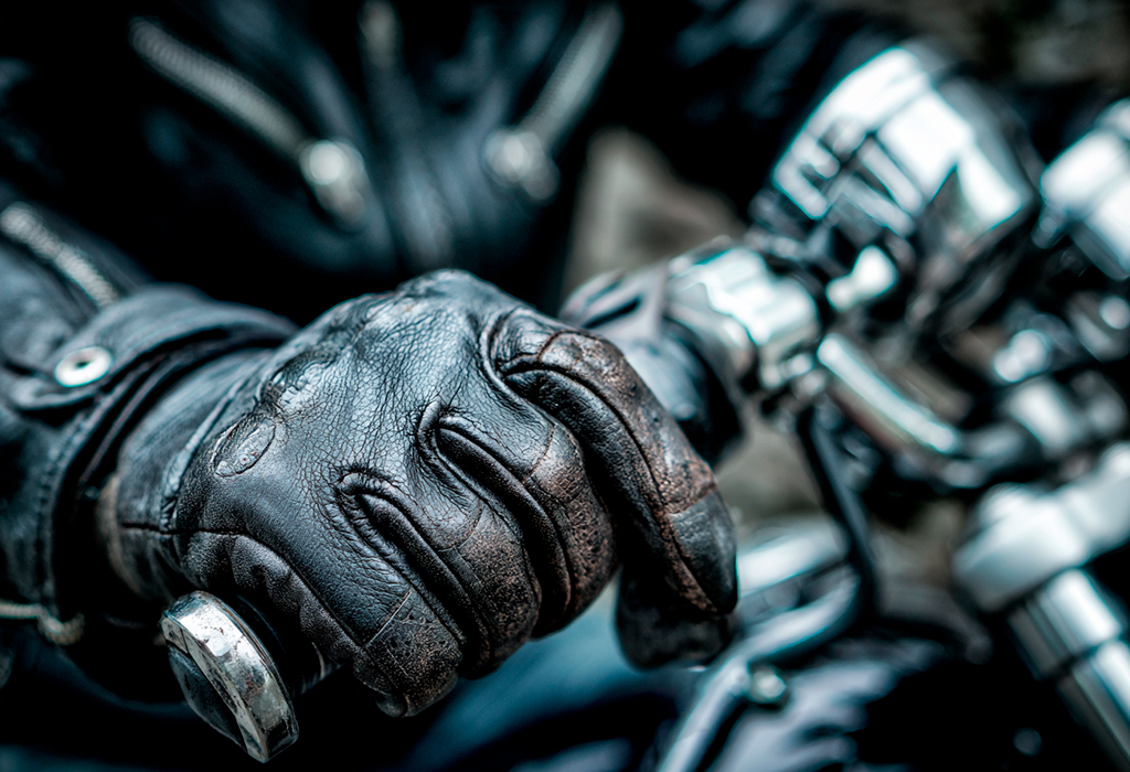 Close-up of biker gloves gripping motorcycle handlebar