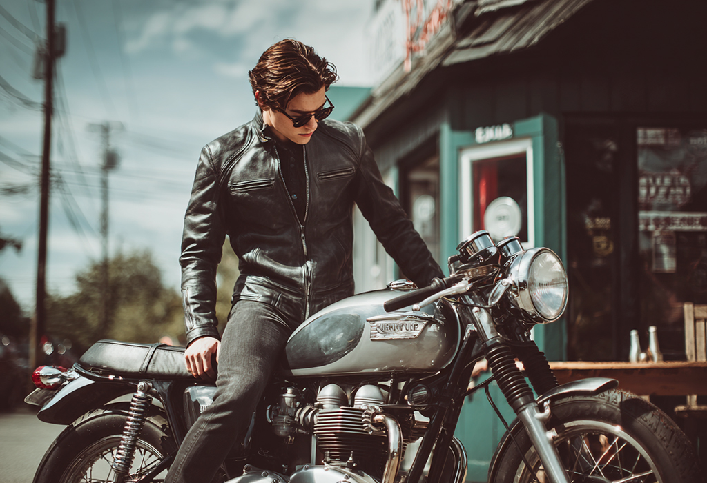 Man in café racer jacket on classic bike